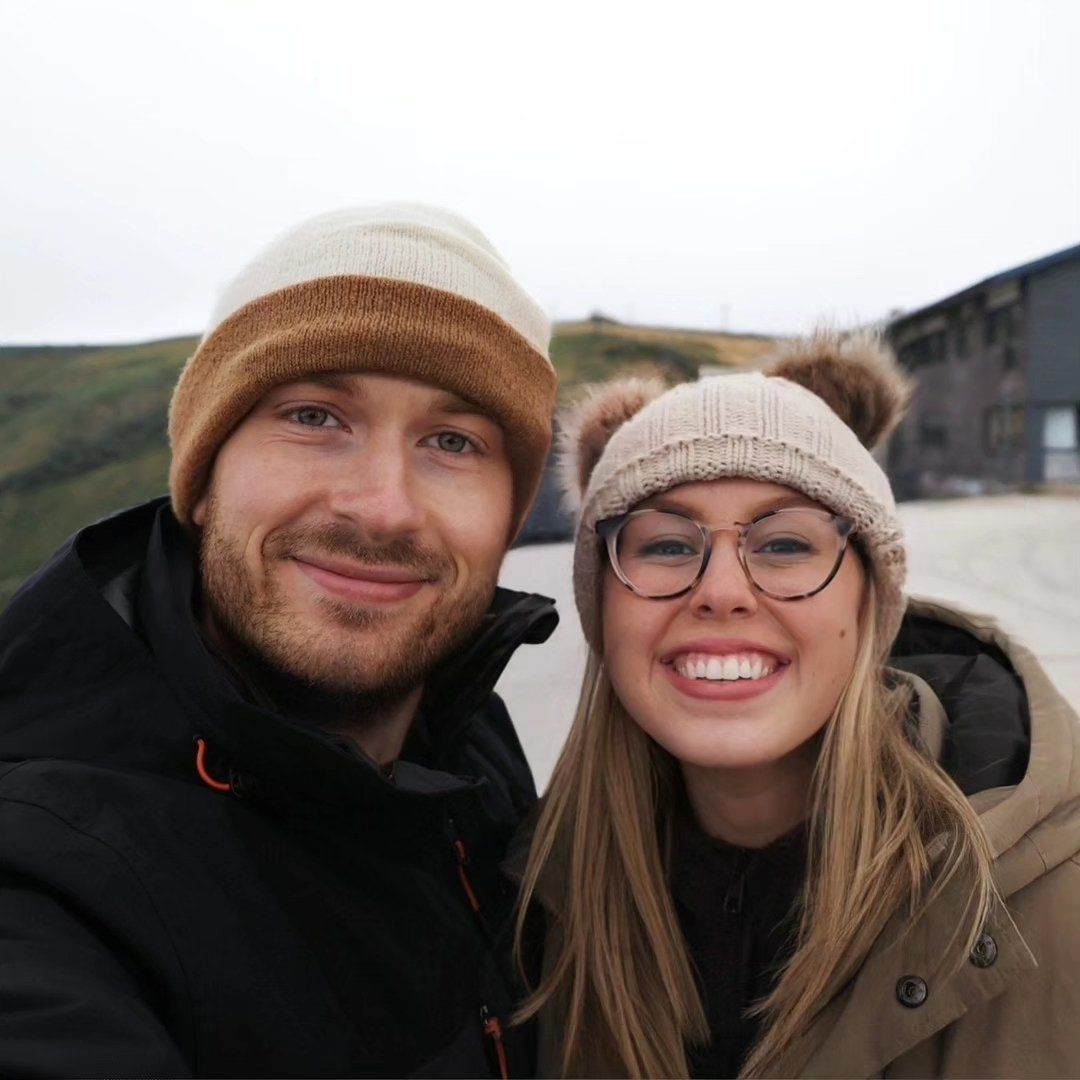 Daniel and Sheridan standing together infront of pine trees