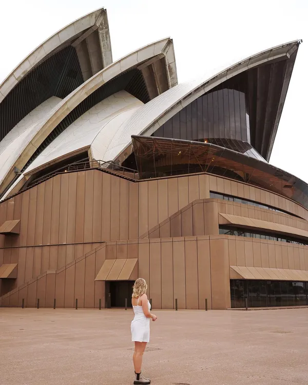 A woman infront of the Sydney Opera House
